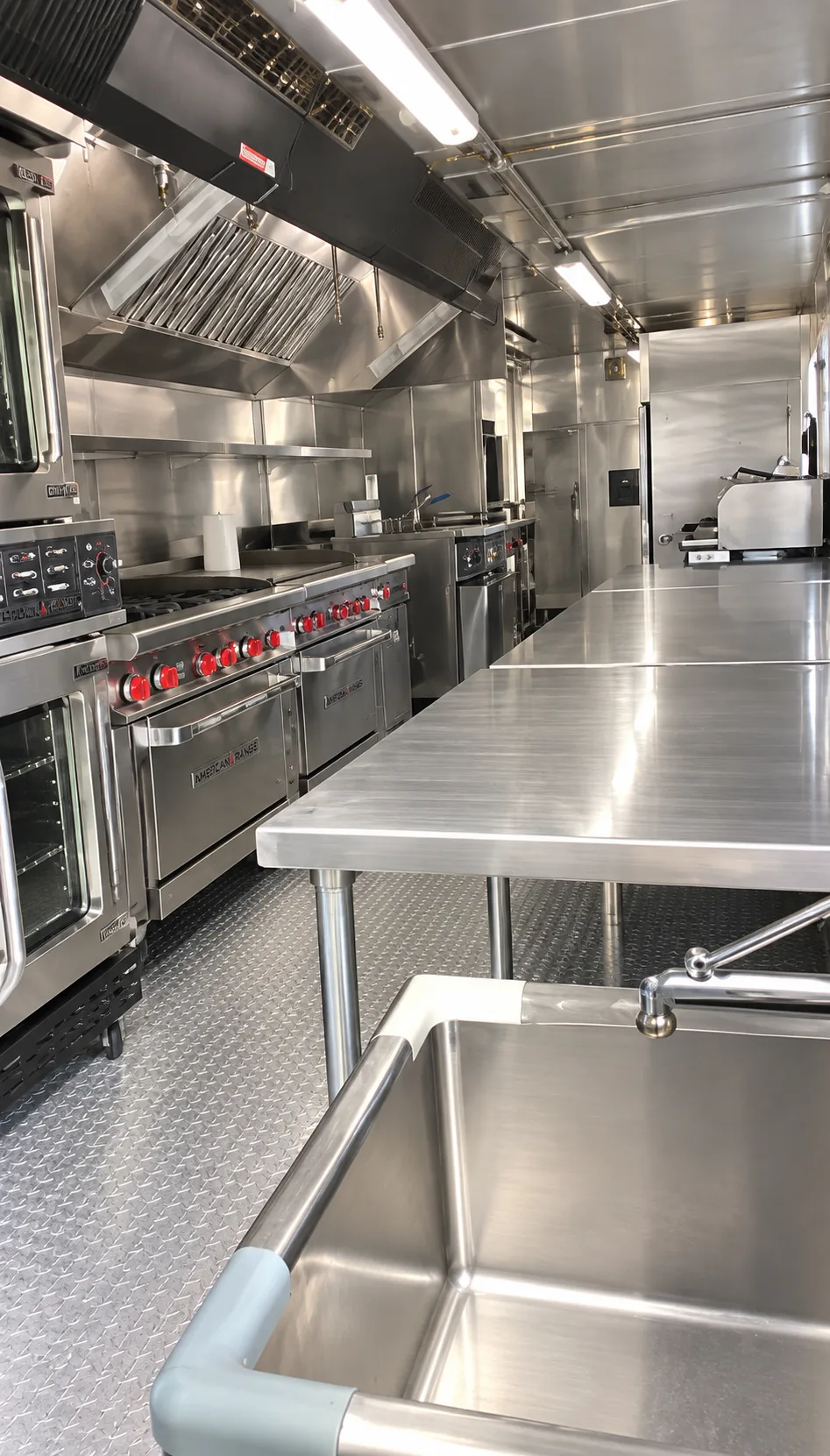Commercial cooking line and stainless preparation counter inside a mobile kitchen trailer